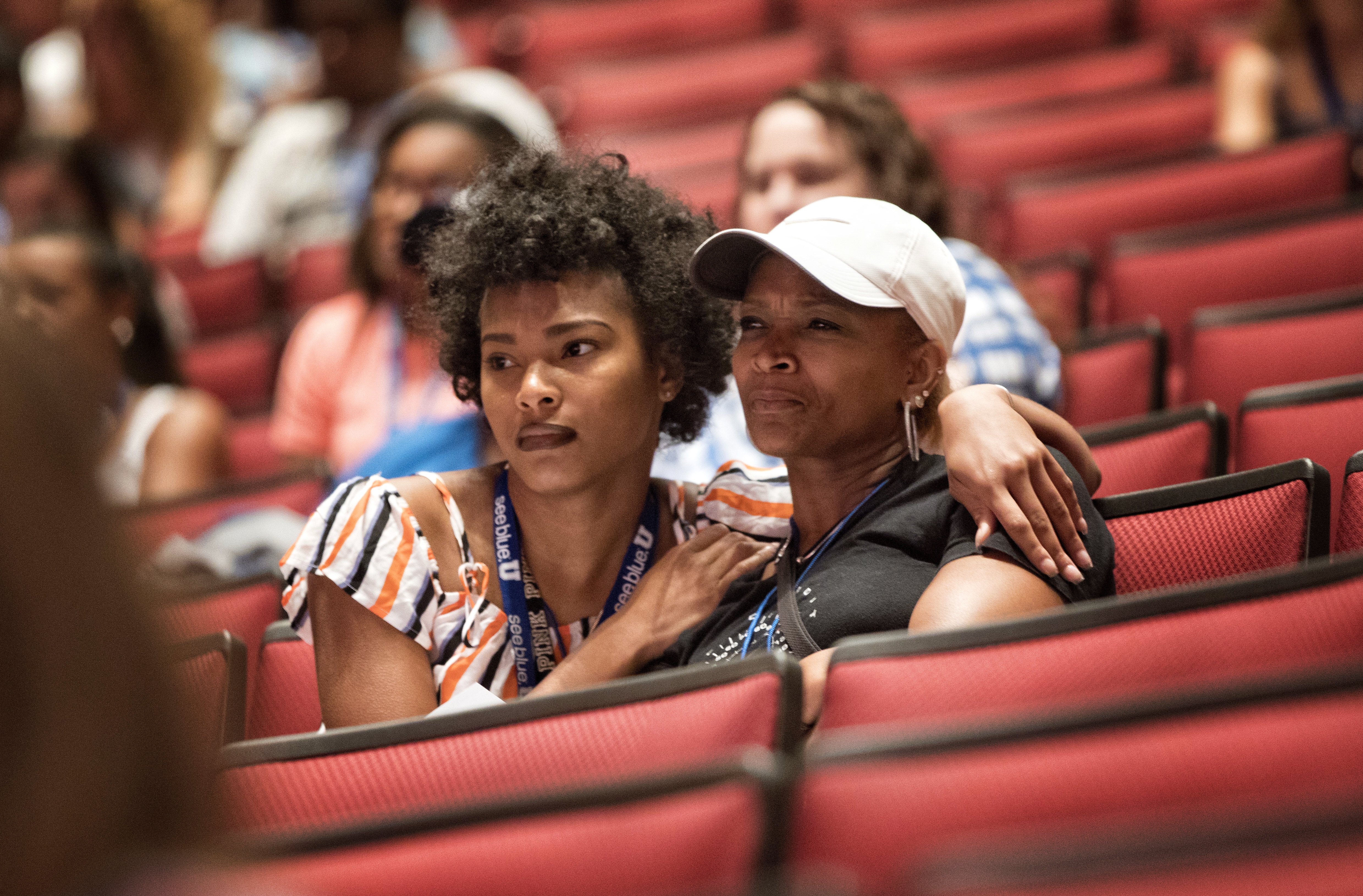  Mother and daughter sit arm in arm while sitting in a Big Blue Nation Orientation session.