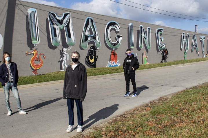 Photo of students in front of mural they created called Imagine Nation