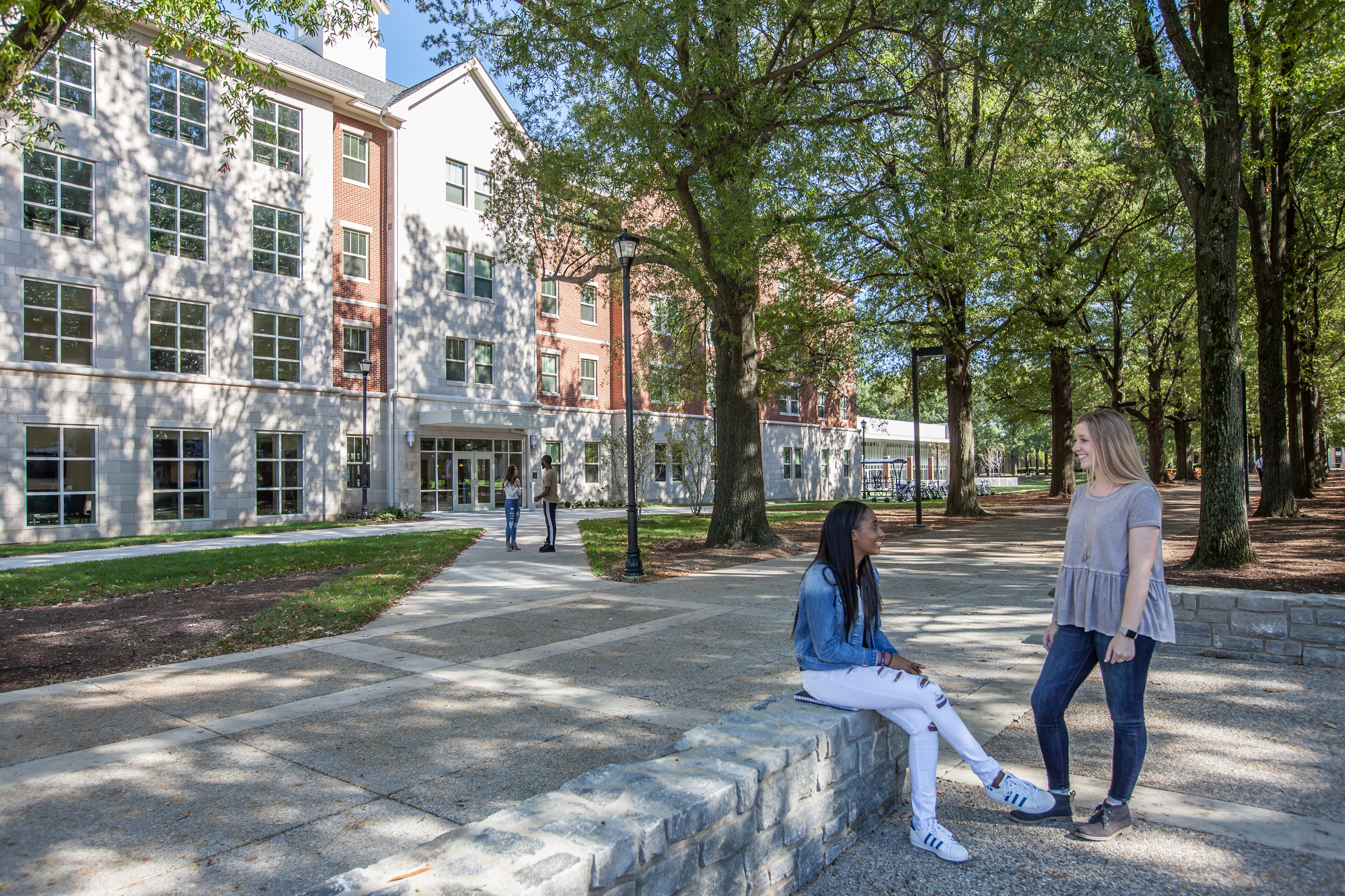 Photo of students sitting on wall outside of Lewis Hall