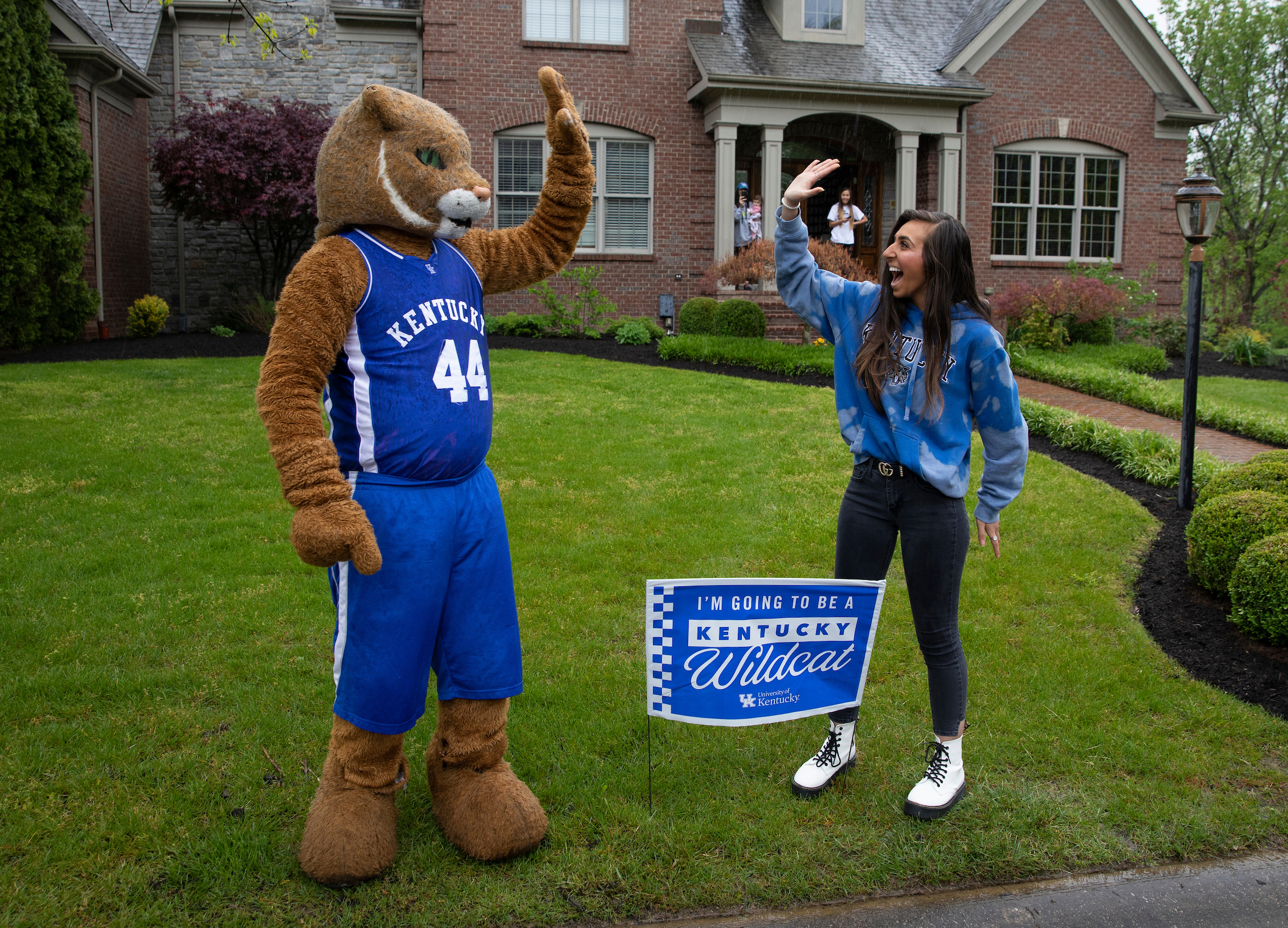 Wildcat and student high fiving in her front yard