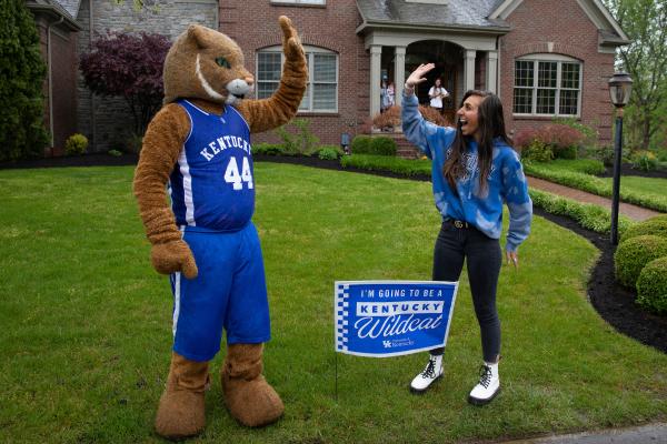 Wildcat and student high fiving in her front yard