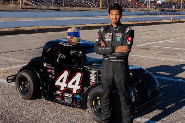 Rahman standing next to racecar