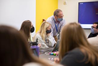 An instructor talks to a table of students.