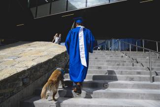 Student with dog at graduation. 