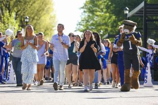 Students walking through Alumni Commons gate as they prepare for graduation