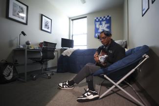 Student in residence hall room playing guitar