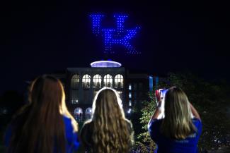 Students looking at UK in lights above library