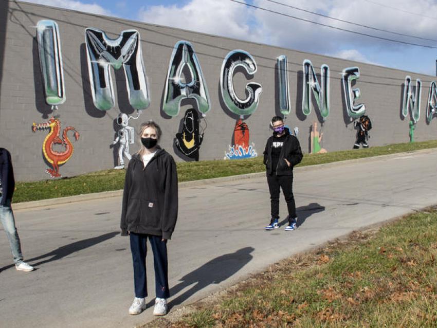 Photo of students in front of mural they created called Imagine Nation
