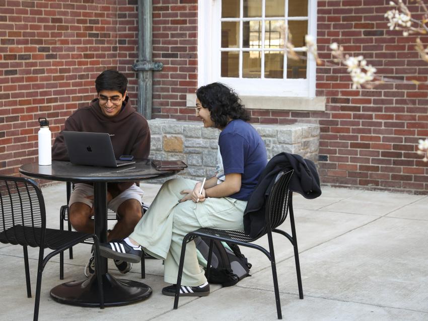 Two students working on a laptop