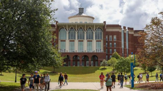 Students walking on campus in front of the William T. Young Library