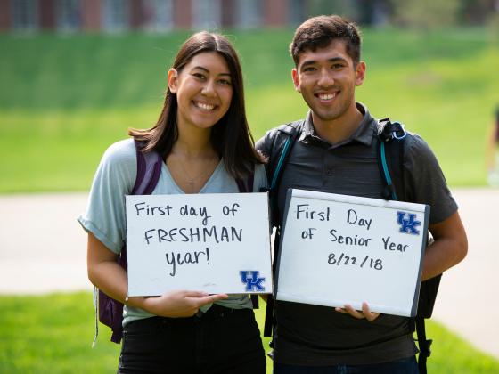 Two students post with "First Day of school signs.