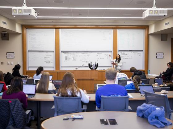 A student presents in front of a business marketing class.