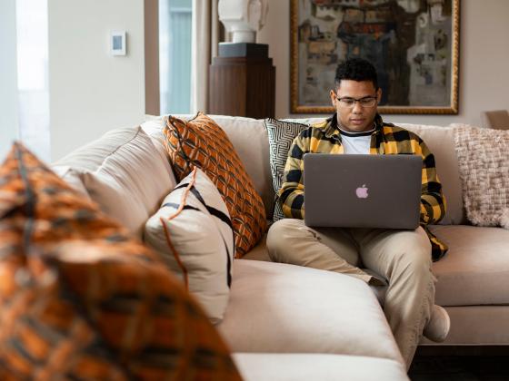 Male student at home on laptop