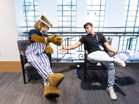 Wildcat shaking hands with a student