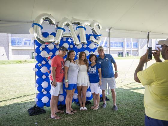 Family posing at Family Weekend Tent