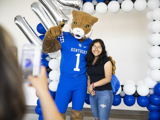 Wildcat and student taking photo